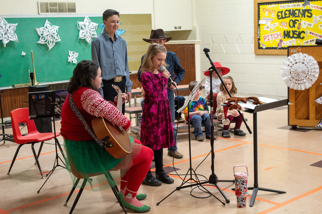 student singing solo as teacher plays guitar