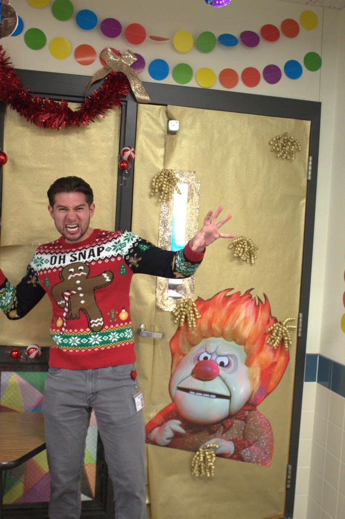 Teacher posing with decorated door