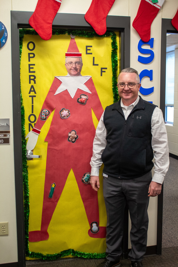 middle aged man standing in front of decorated door