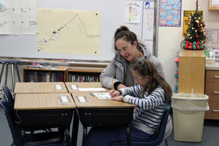 student wokring on math problems with family member