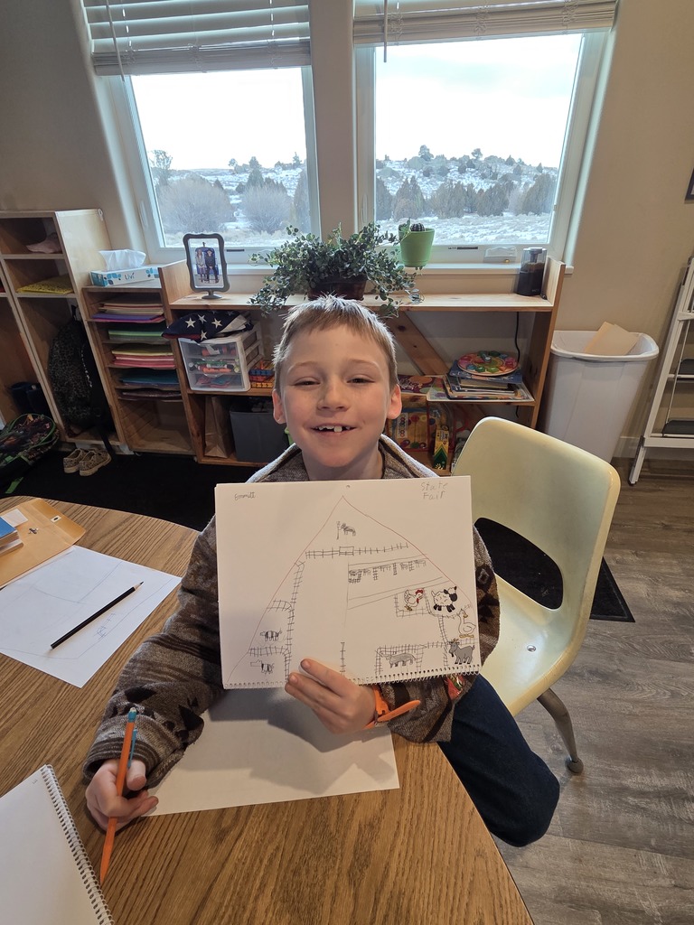 young boy with blonde hair holding artwork