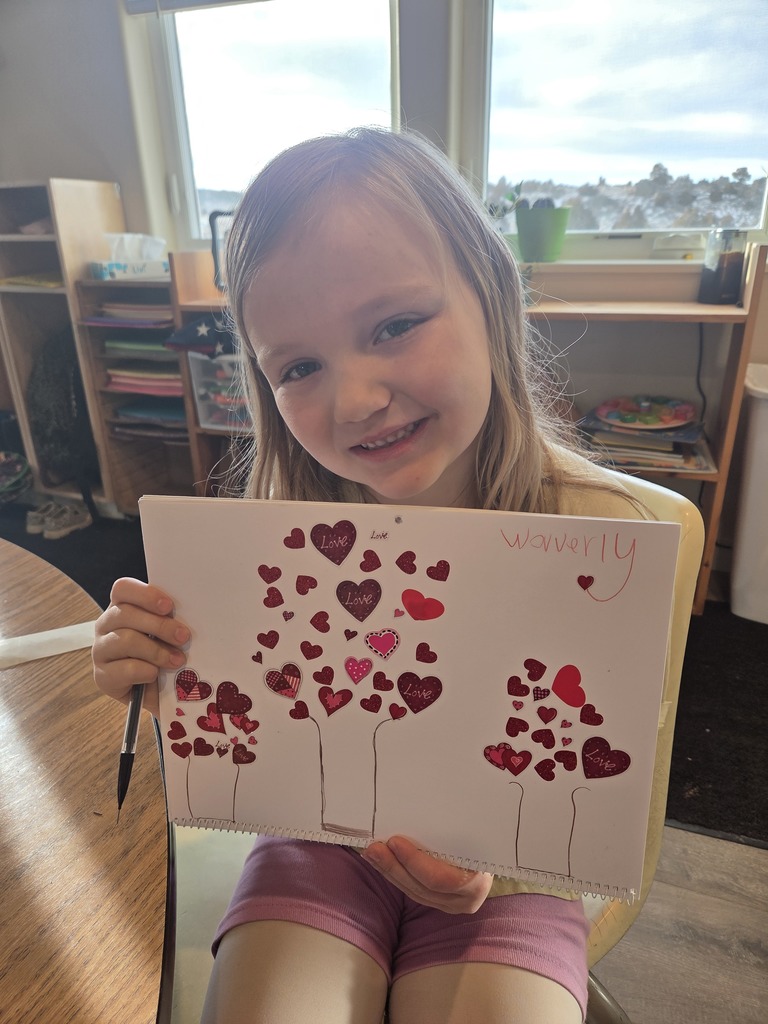 young girl with blonde hair holding artwork