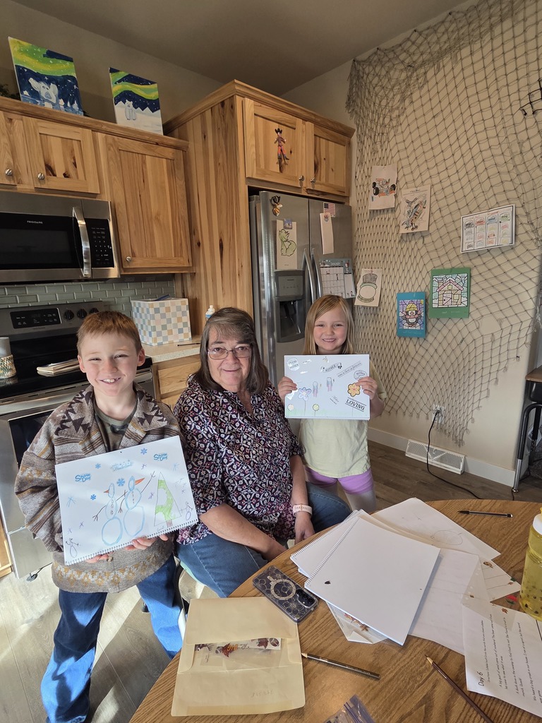 young male and female student holding artwork standing next to teacher