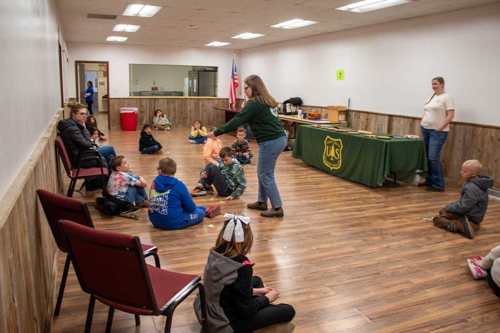 students sitting on floor while instructor throws confetti 