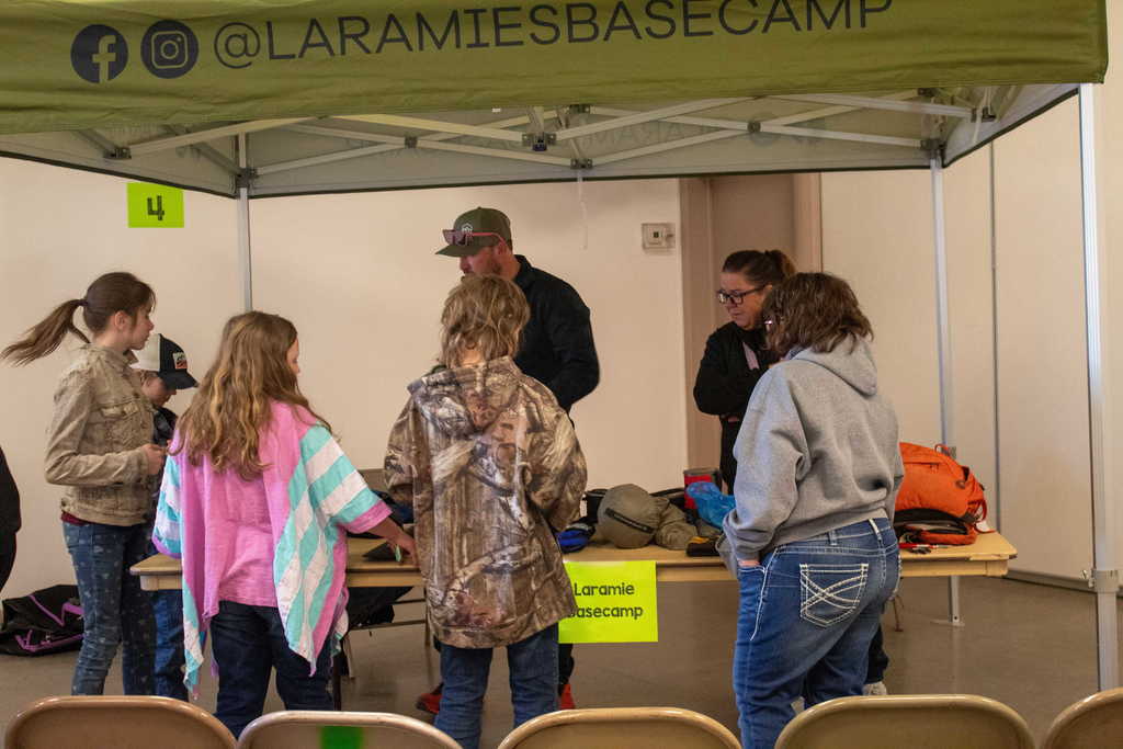 young students gathered around a table of camping gear