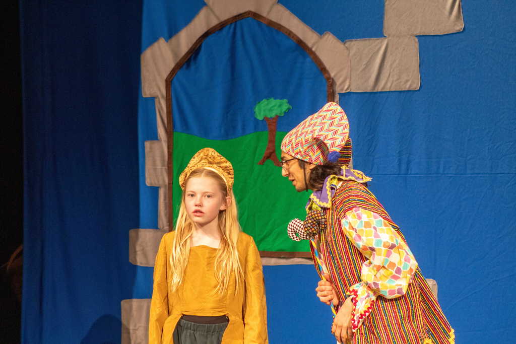 student dressed as a queen talking with a jester