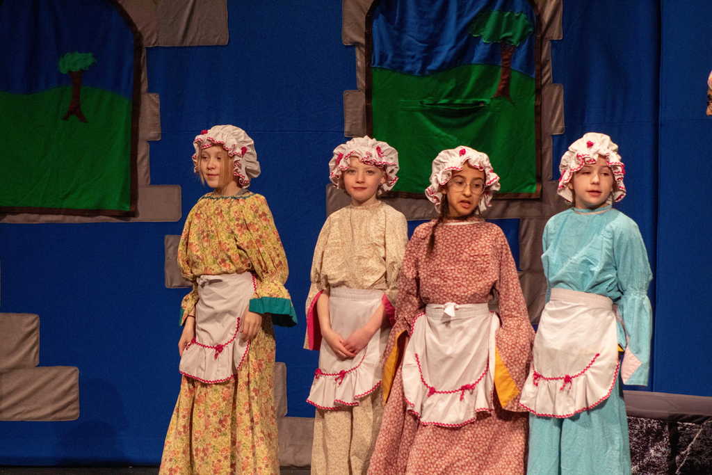 Four young girls dressed as maids on stage