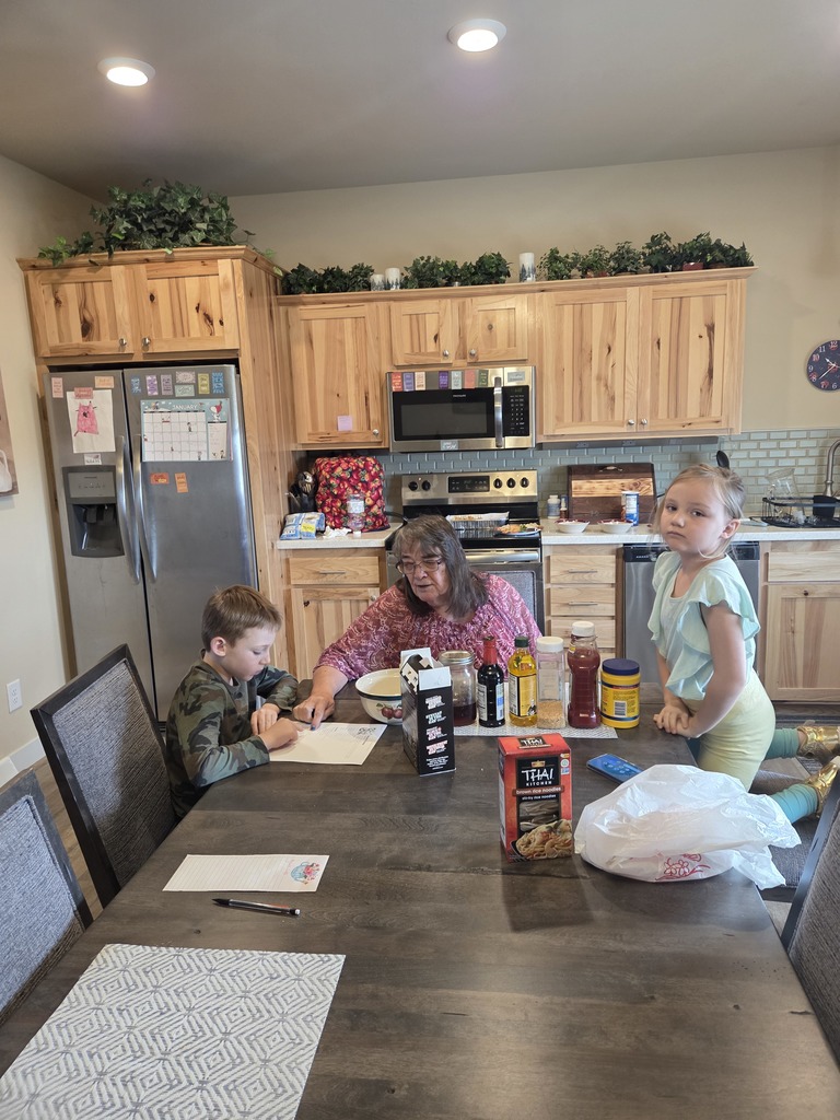 Young boy and girl lookling at papers on a table with teachers