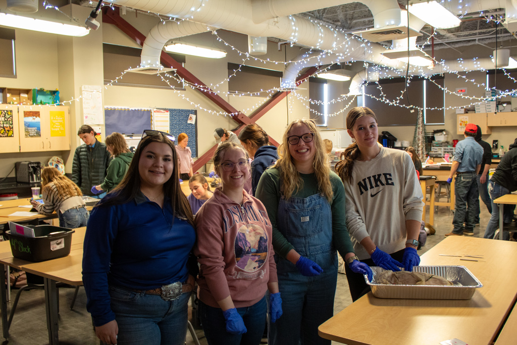 Four girls posing with science project