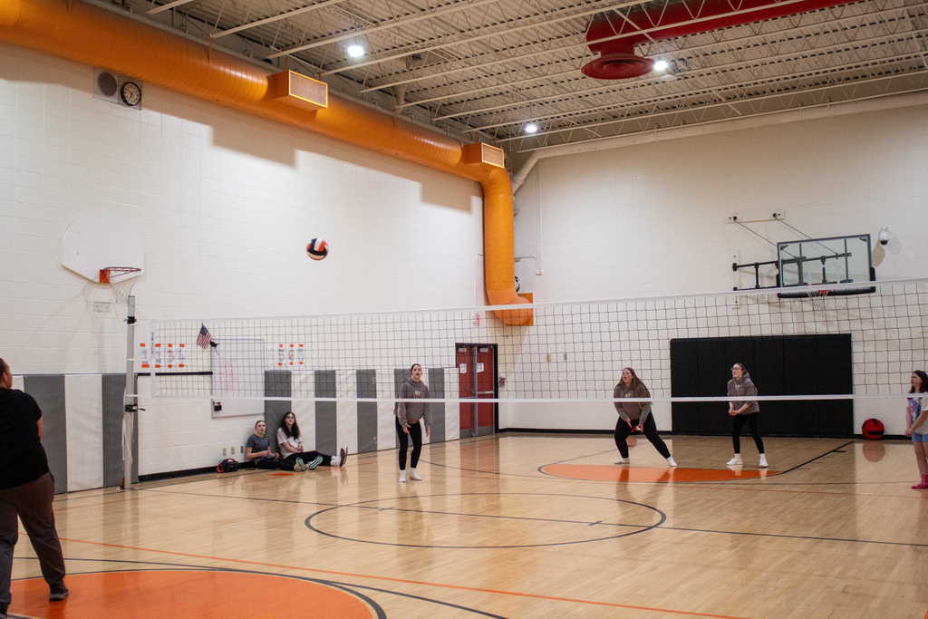 Students playing volleyball in a gym