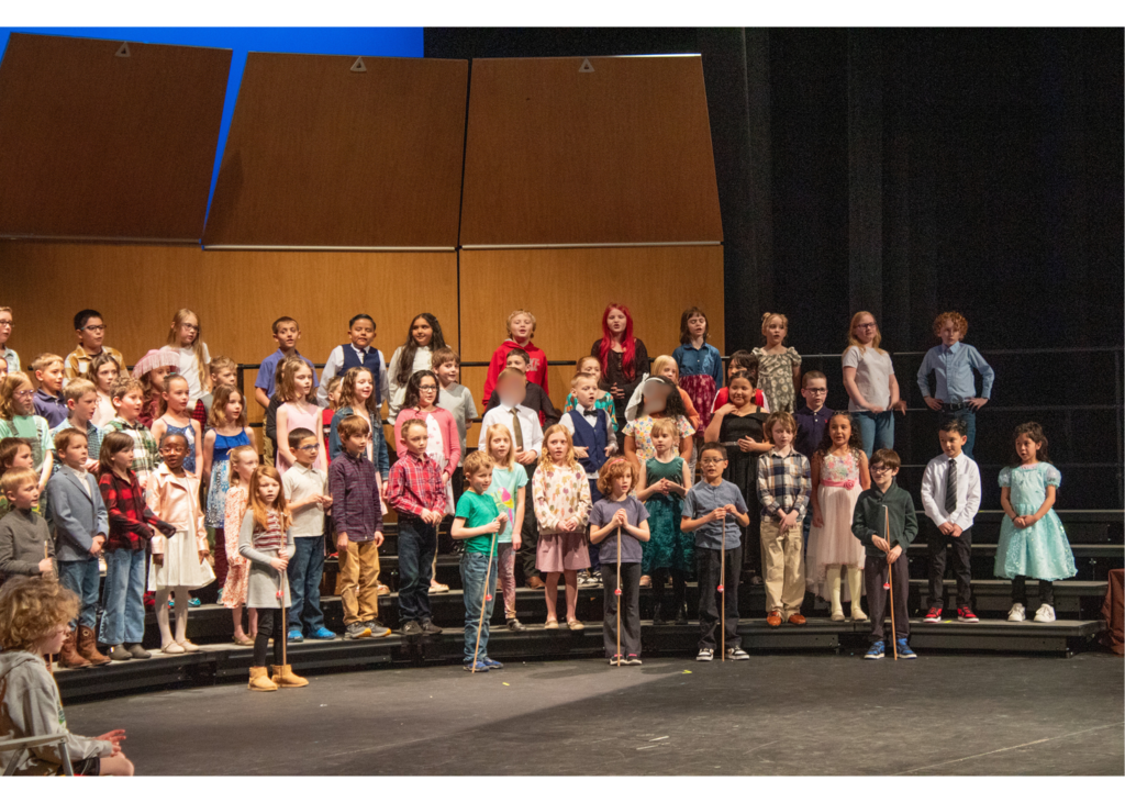 Elementary students stationed on a riser on a stage