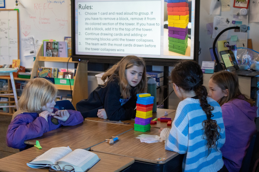 Group of three girls stacking colored blocks on a desk
