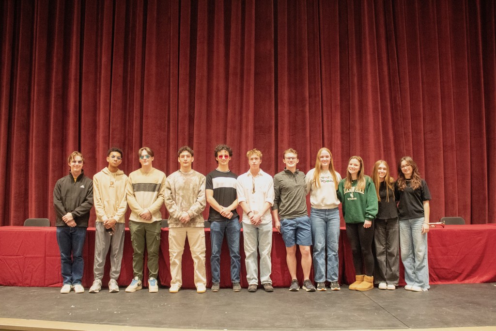 Group of eleven high school students standing on stage in row