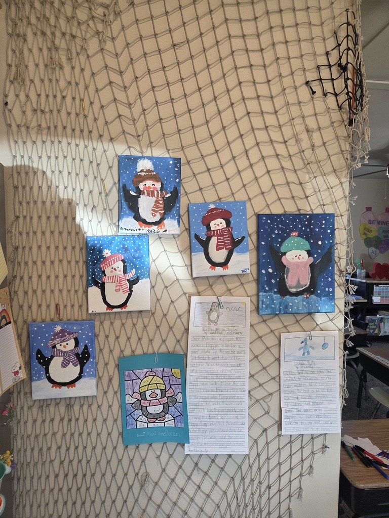 Penguin paintings and school projects hung on a wall