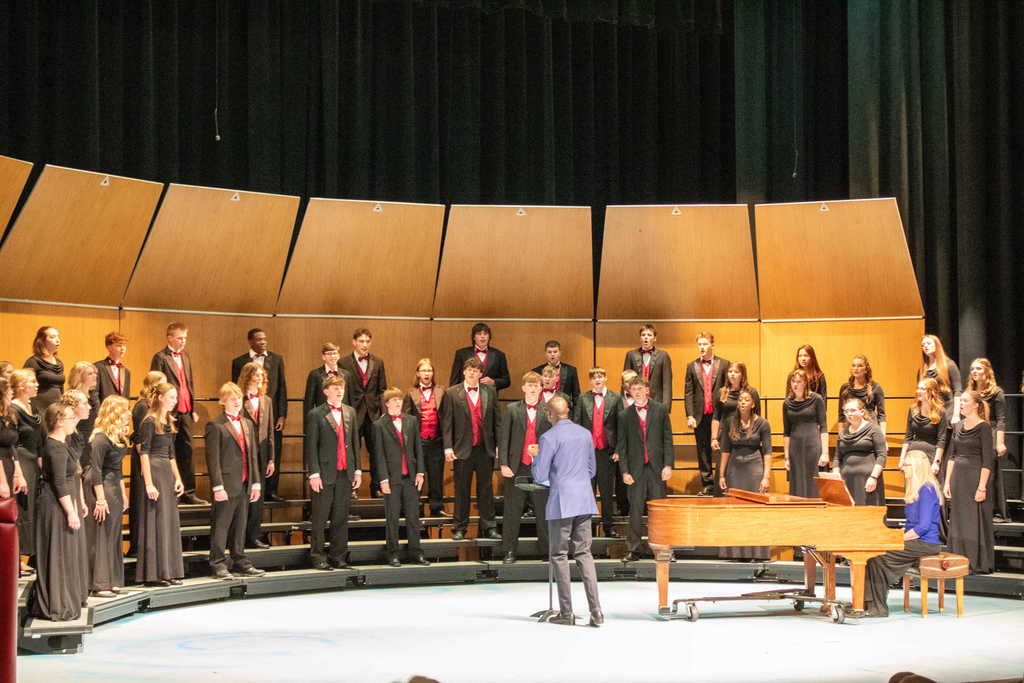Students in choir singing and dancing on stage