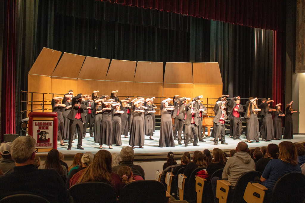 Students in choir singing and dancing on stage