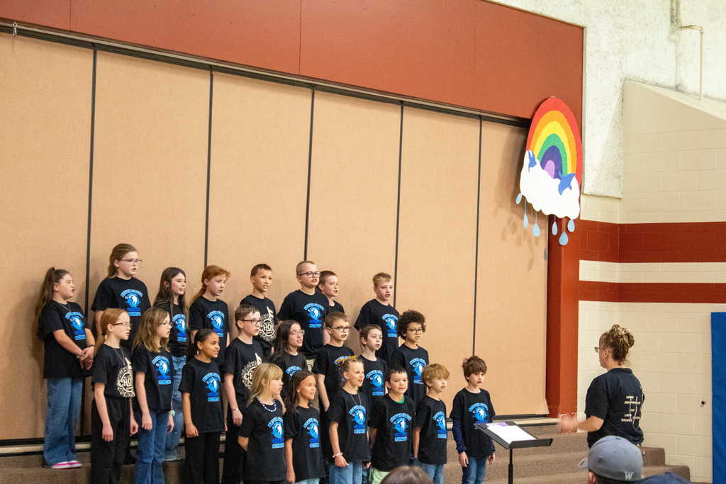 Choir students performing in front of the gym