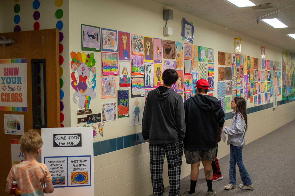 Siblings and parents looking at artwork on a wall