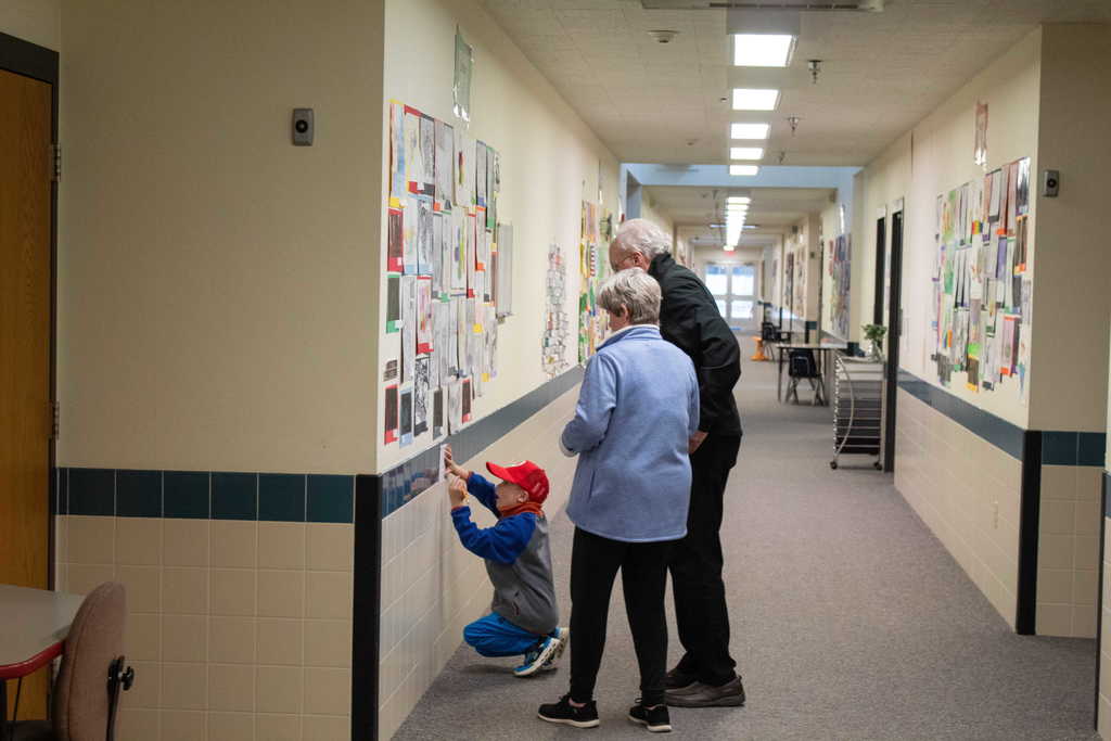 Grandparents and young boy looking at artowrk on a wall
