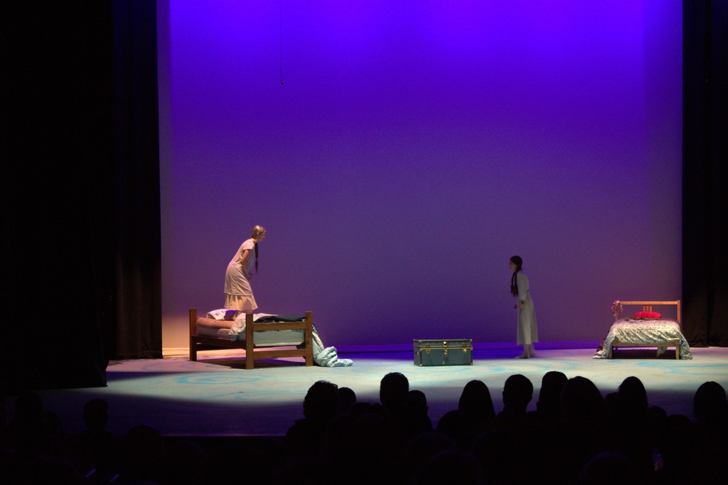 two girls on stage singing 
