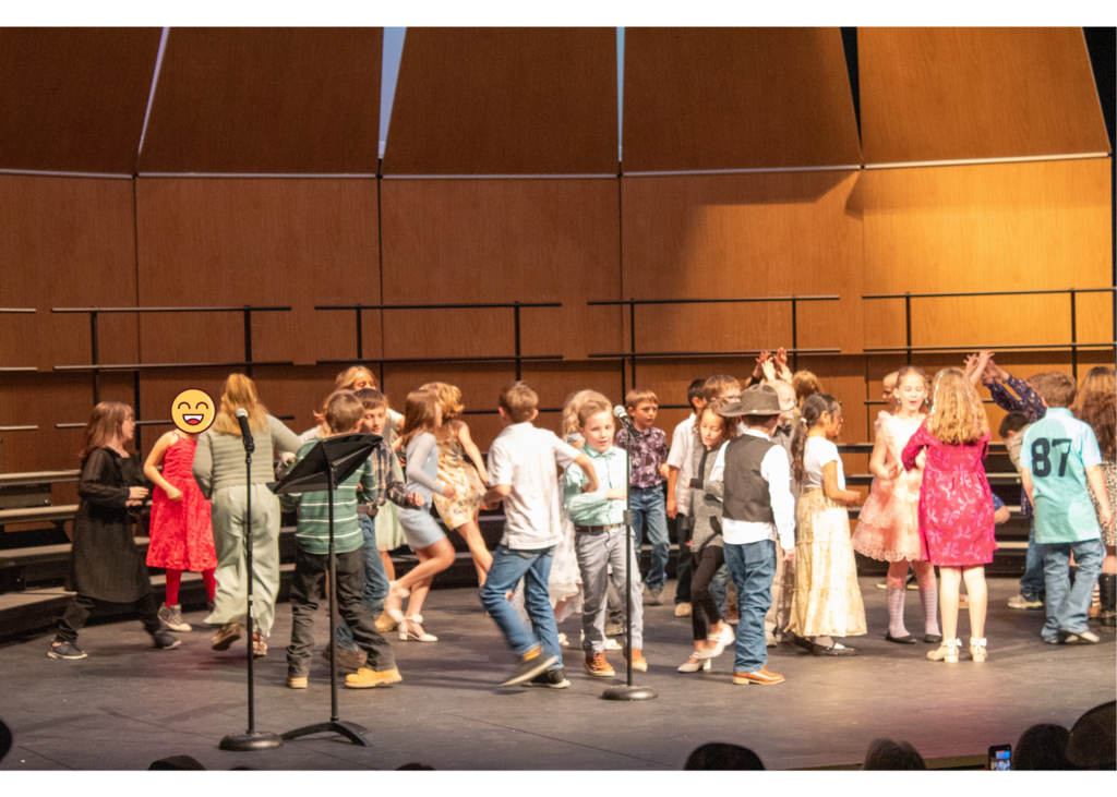 Students dancing around in circles on a stage
