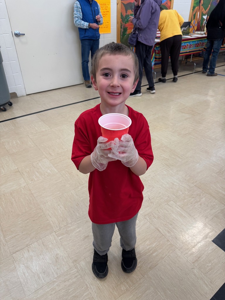Little boy with brown hair holding a red  cup