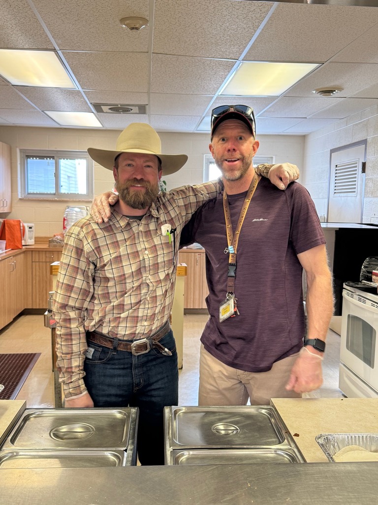 Two men with arms around each other smiling for the camera