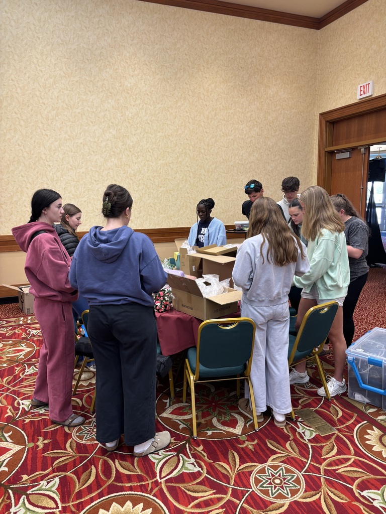 Group of high school students standing around a table of decorations