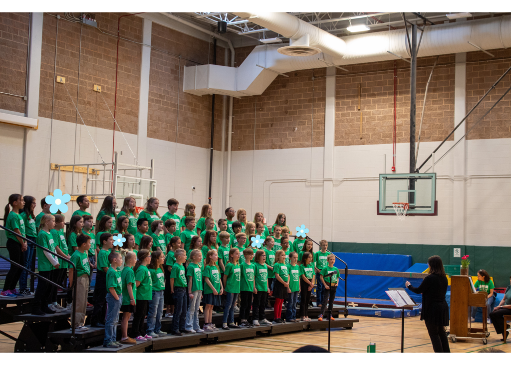 Groups of students all dressed in green t-shirts standing on risers