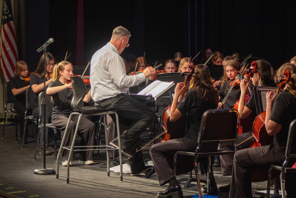 Students playing their instruments alongside their teacher