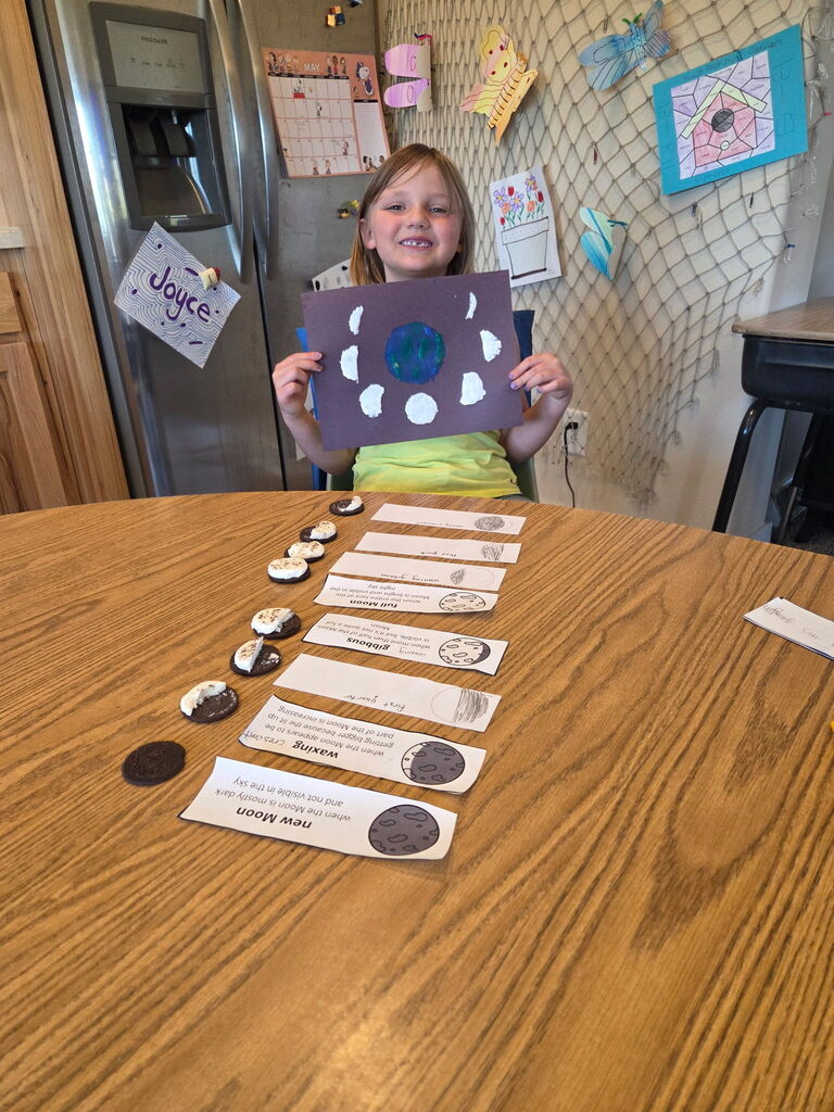 Young girl holding a paper showing the different moon cycles