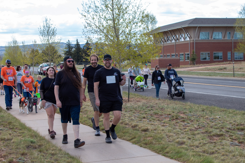 Group of men, women, and children walking sidewalk