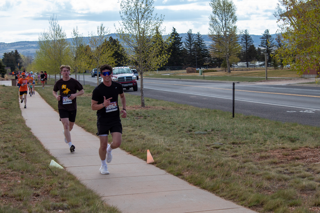 Group running alongside sidewalk