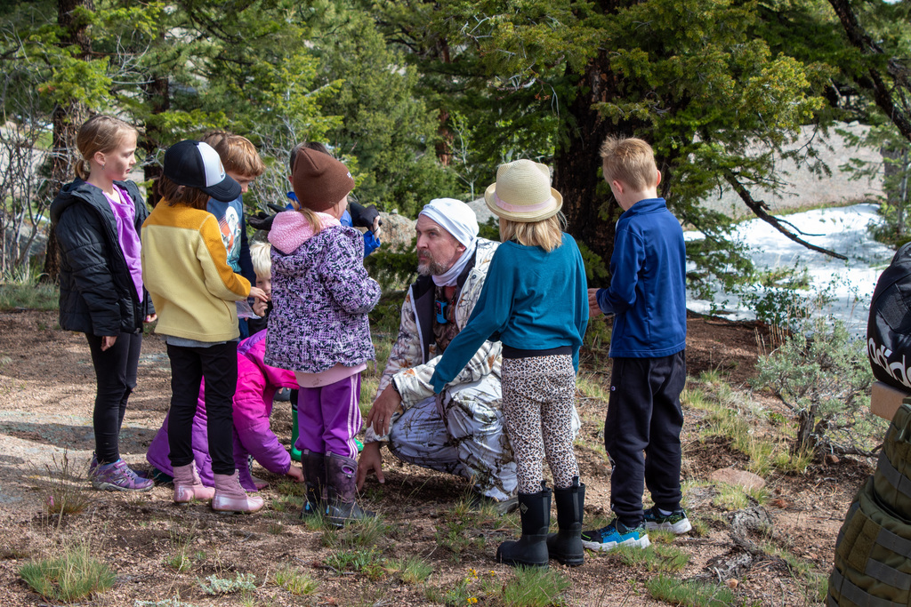 Students gathered around a man dressed in camoflauge