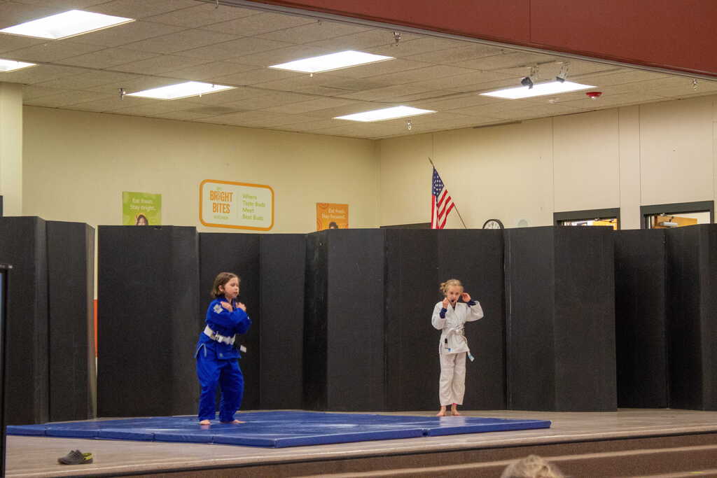 Two girls doing jujitsu on stage
