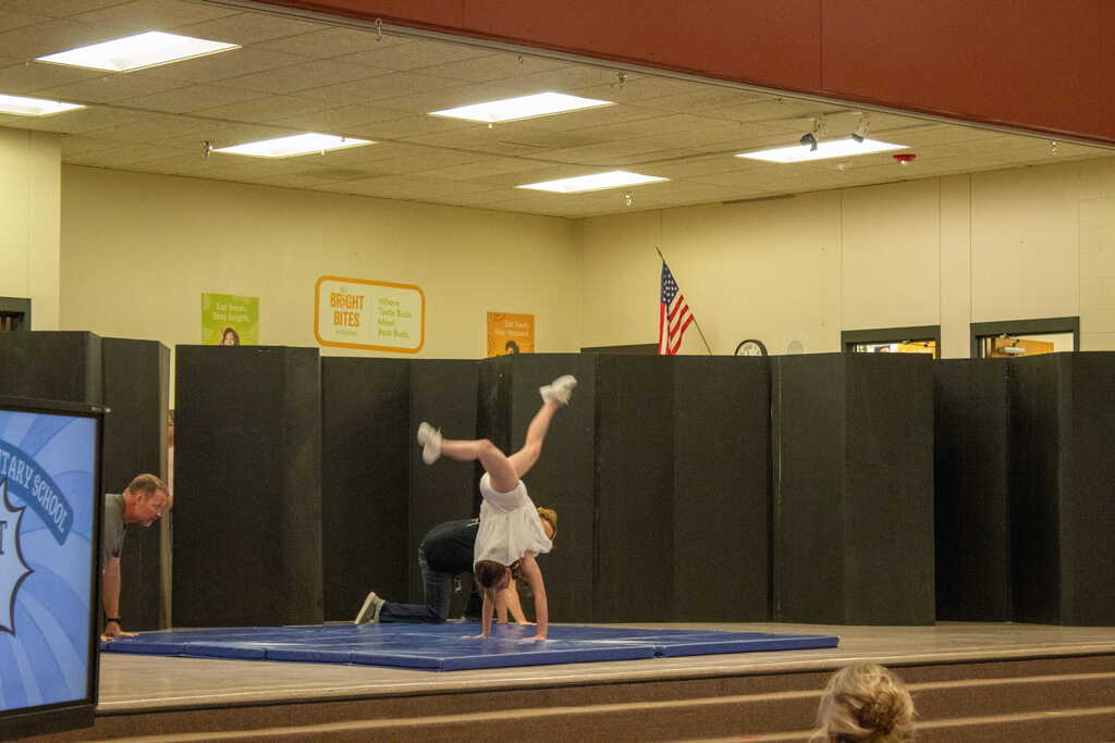 Girl dressed in all while doing a cartwheel