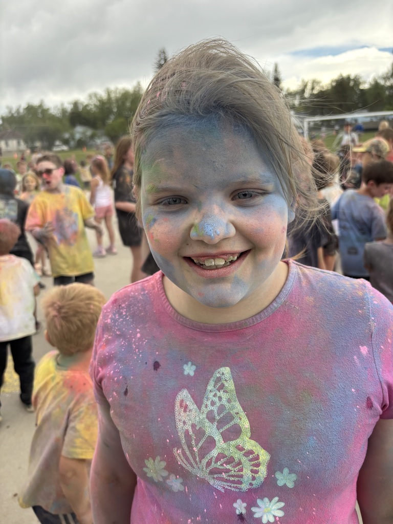 Young girl with brown hair and purple t-shirt covered in color powder