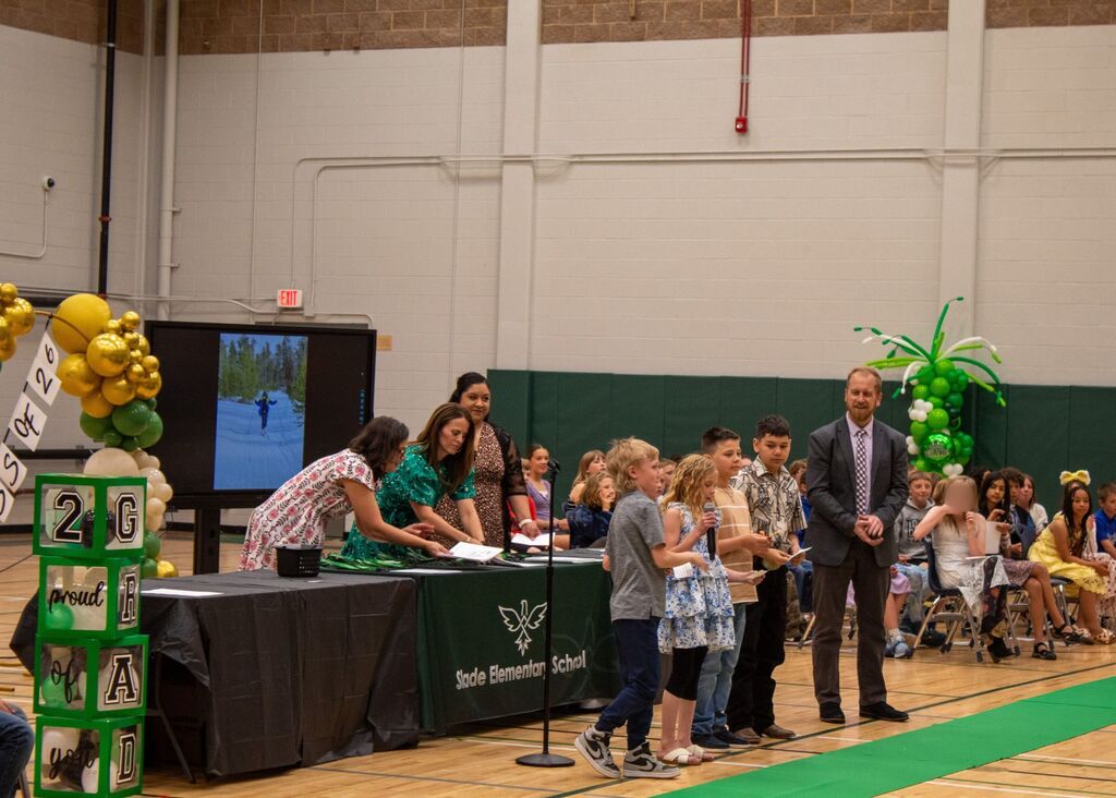 Student standing to receive award in front of peers, staff,  and family