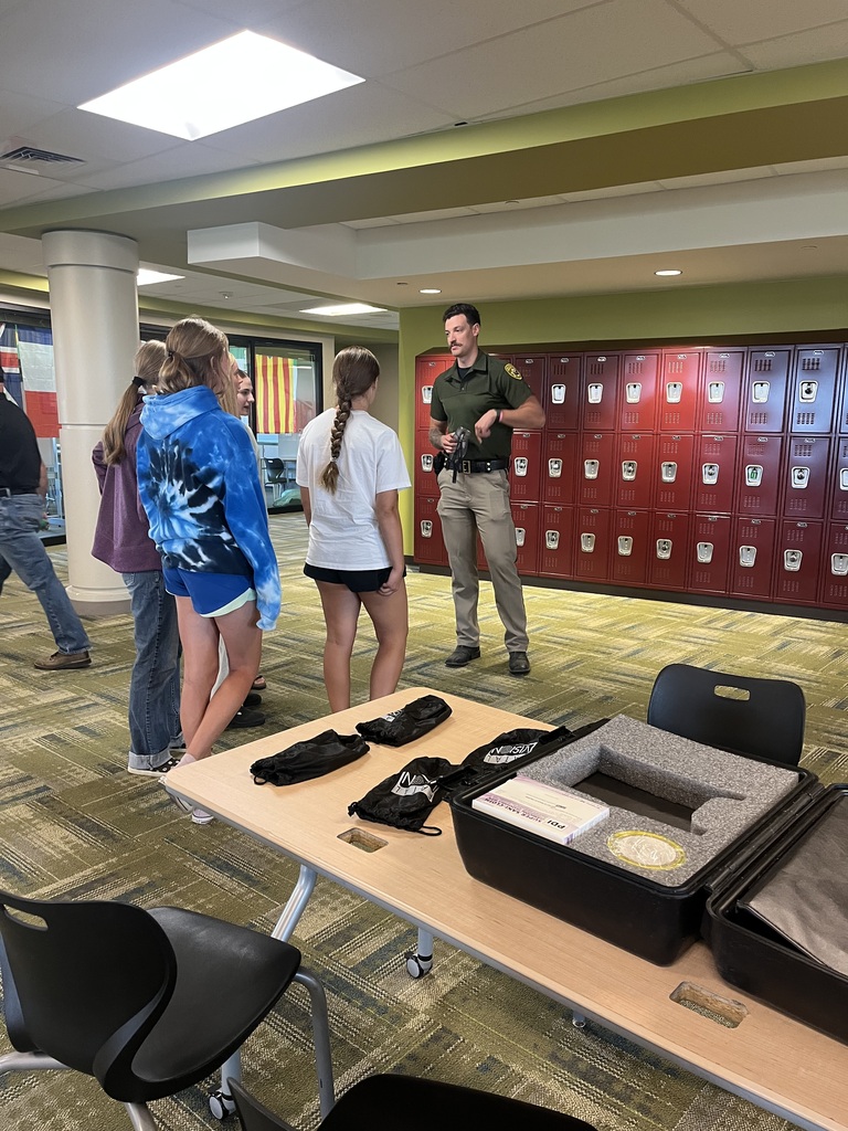 Thre female students standing in front of an officer