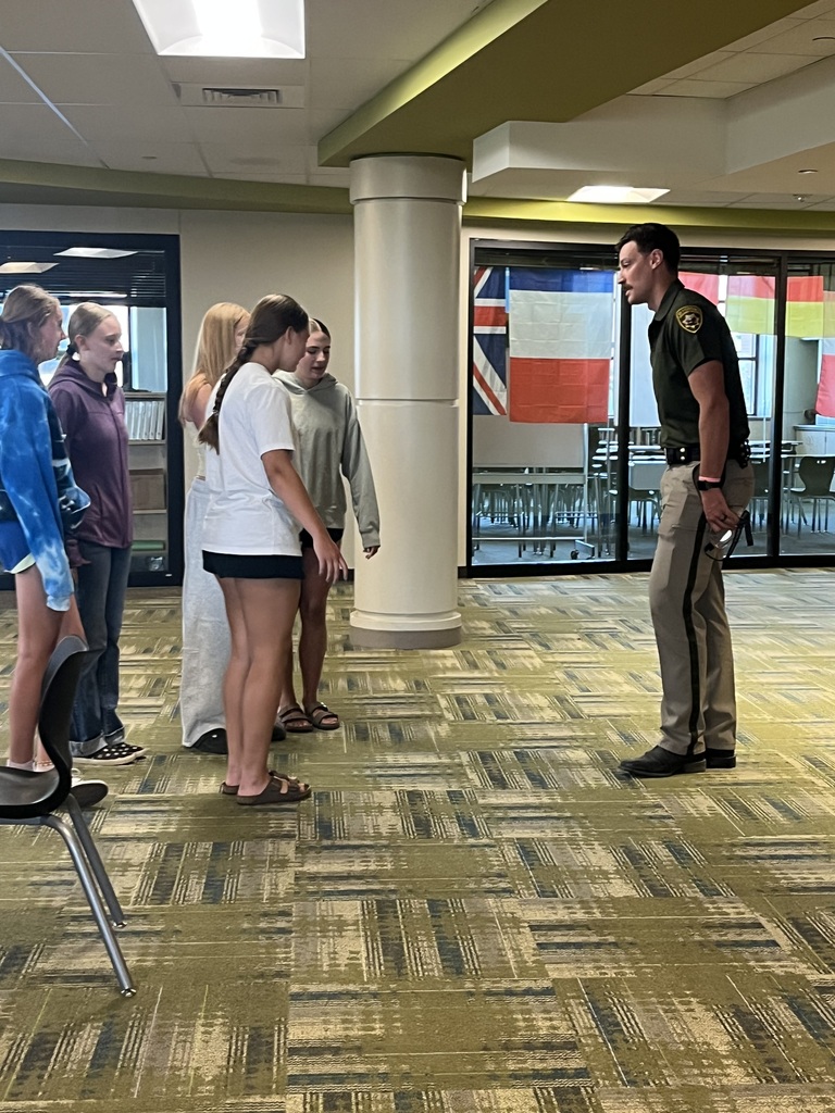 Group of students listening to an officer speak
