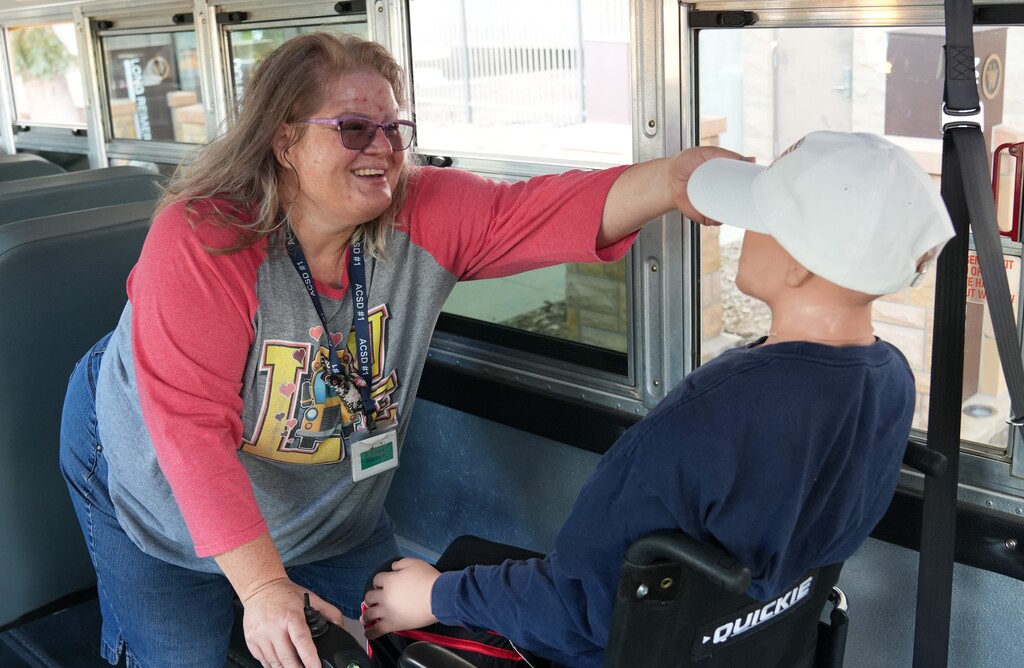 Woman in pink shirt setting up a safety demonstration