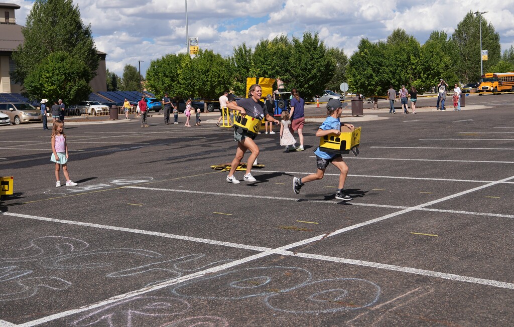 Mother and son running a race holding up yellow boxes