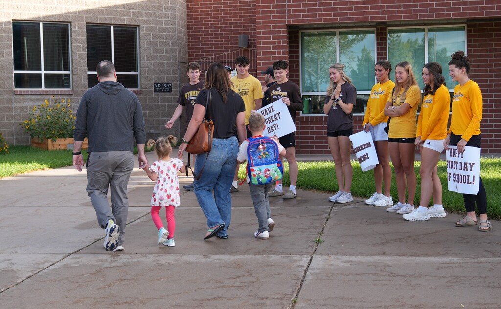Students walking by UW athletes getting high fives as they walk into school