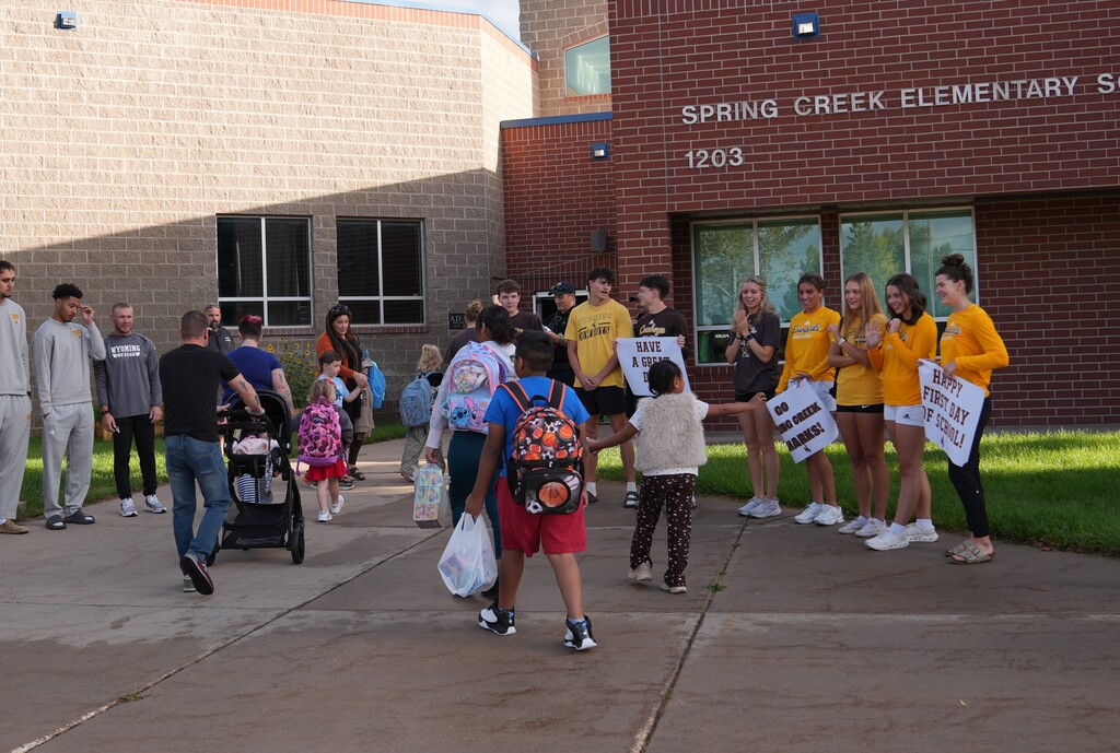 Students walking by UW athletes getting high fives as they walk into school