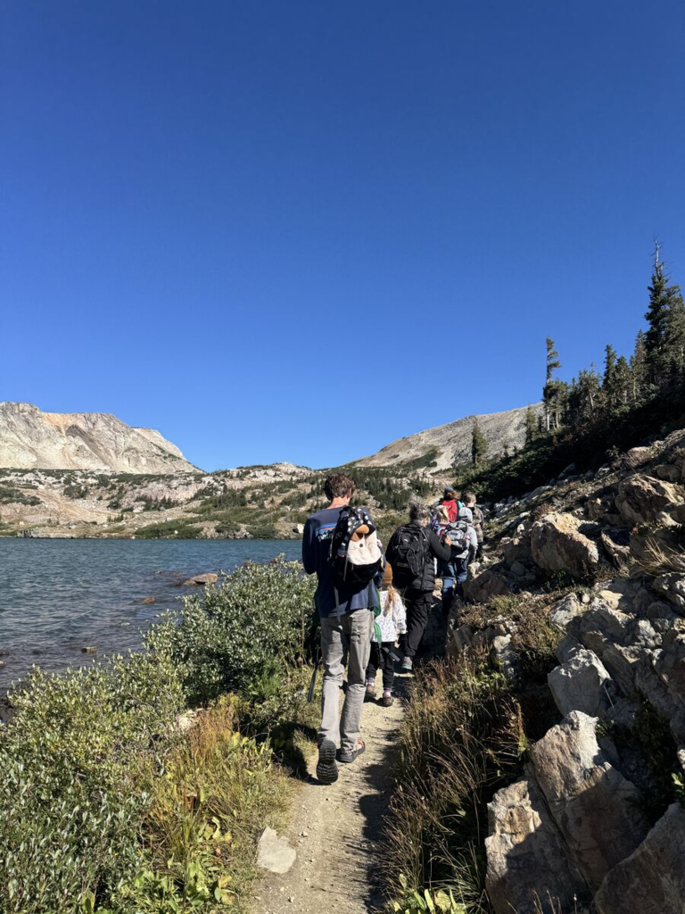 Students hiking a trail around a lake