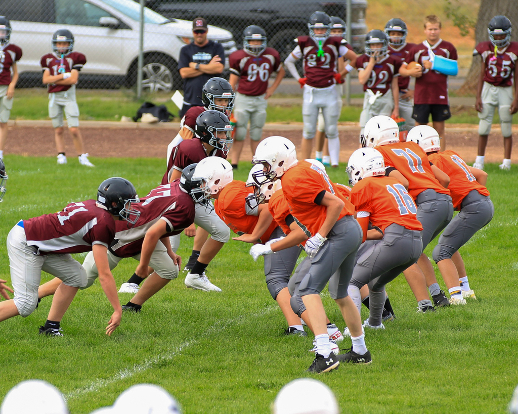 Football team on field preparing to start a play