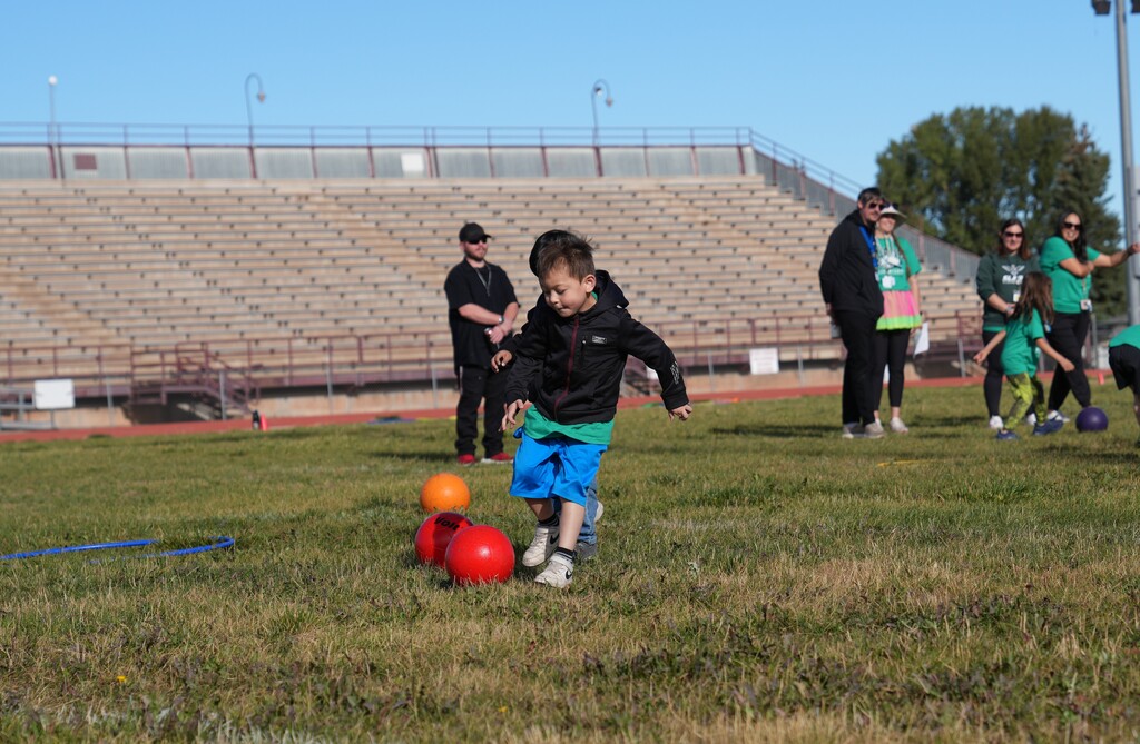 Little boy kicking a red soccer ball