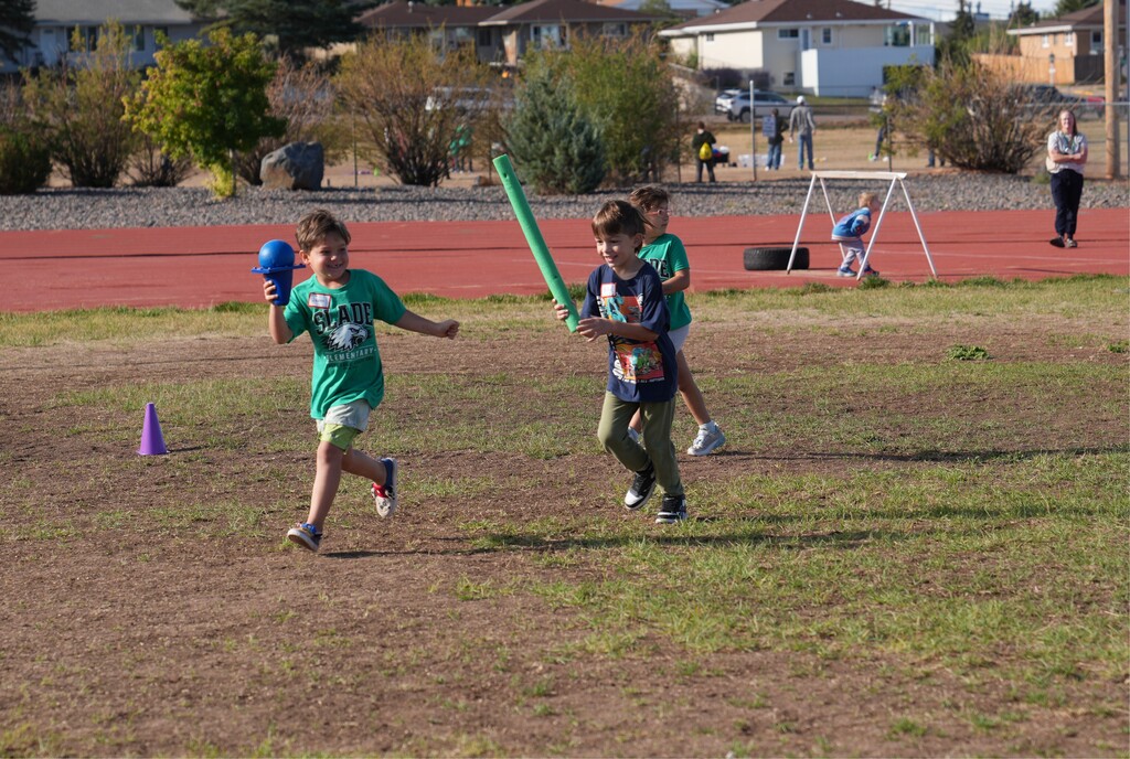 Little boy chasing anther little boy who is carrying a ball