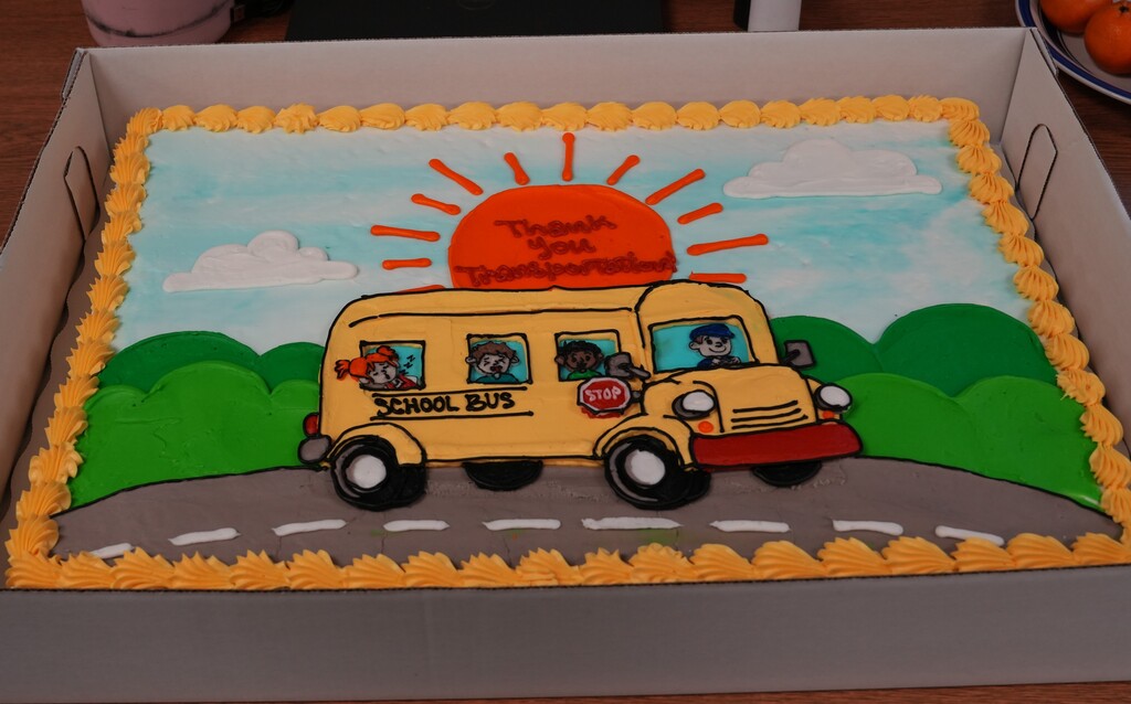 Cake decorated with a yellow school bus driving down the road