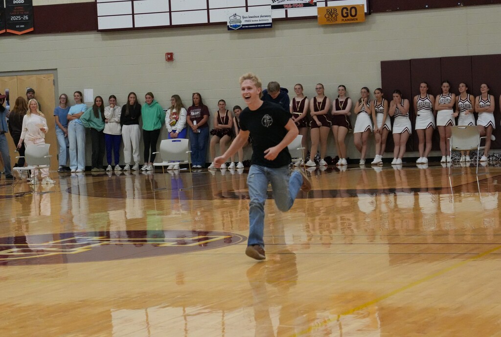 Boy in jean and black shirt running across the gym